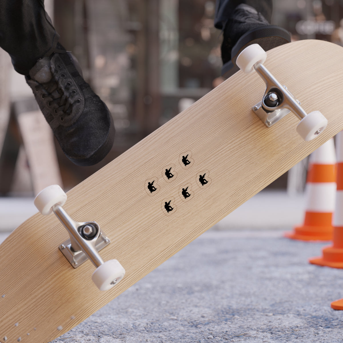Skateboard with 'FREEDOM' branding held by a person, with traffic cones in the background.