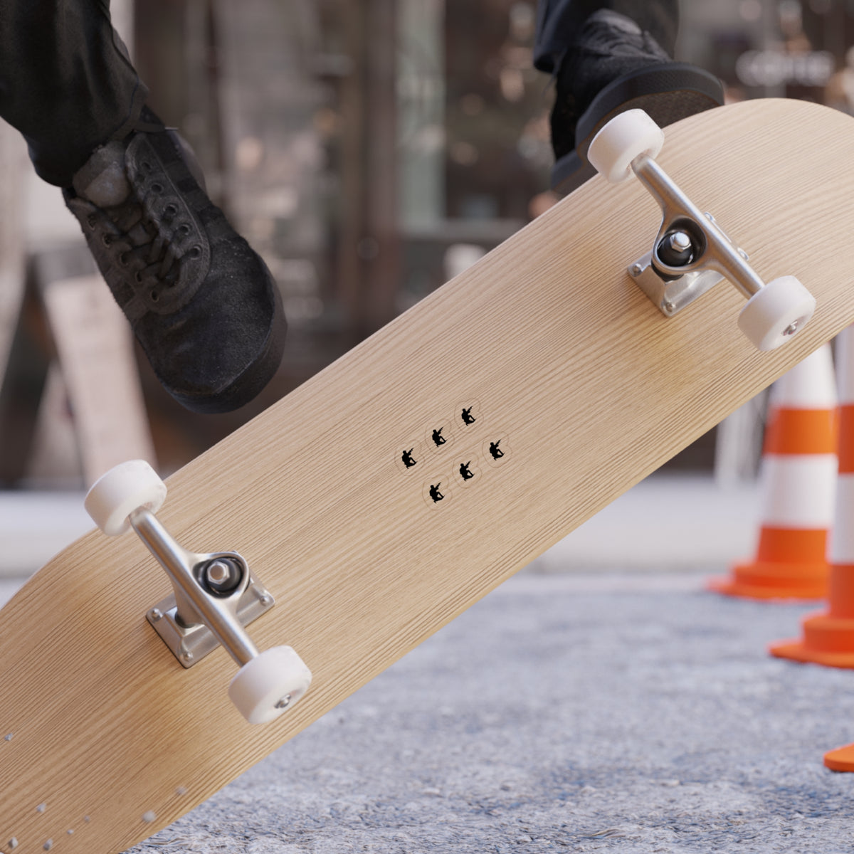 Skateboard with 'Freedom' branding held by a person, blurred background with traffic cones.